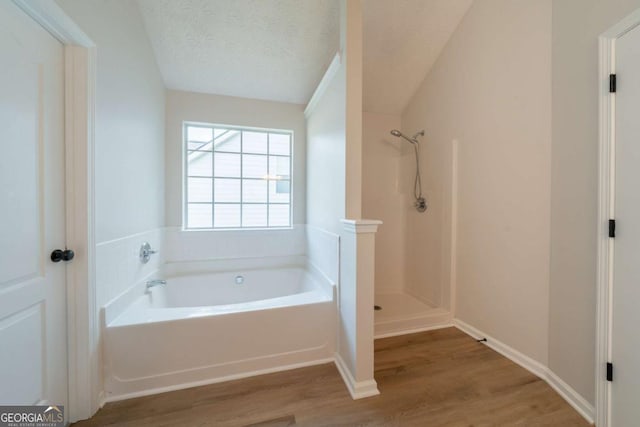 4815 Price St, Forest Park, GA 30297 - bathroom featuring wood finished floors, a garden tub, a textured ceiling, and a shower