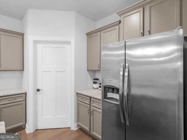 401 Mountain Dr, Monroe, GA 30655 - kitchen with stainless steel fridge, tasteful backsplash, wood finished floors, and light stone counters