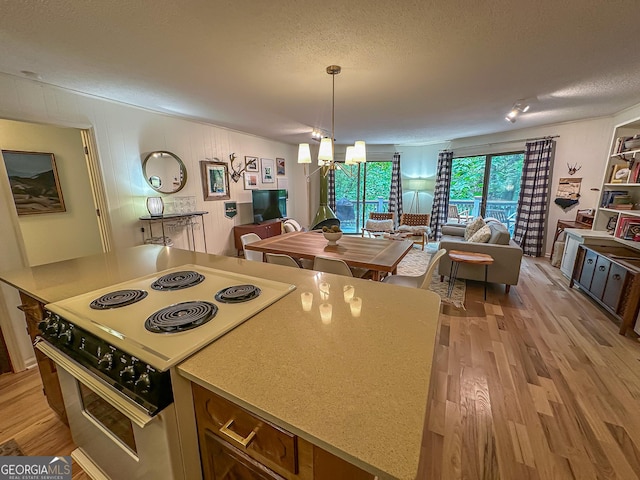 278 W Sugarbush Dr, Dillard, GA 30537 - kitchen featuring range with electric stovetop, light wood-style floors, a textured ceiling, hanging light fixtures, and open floor plan