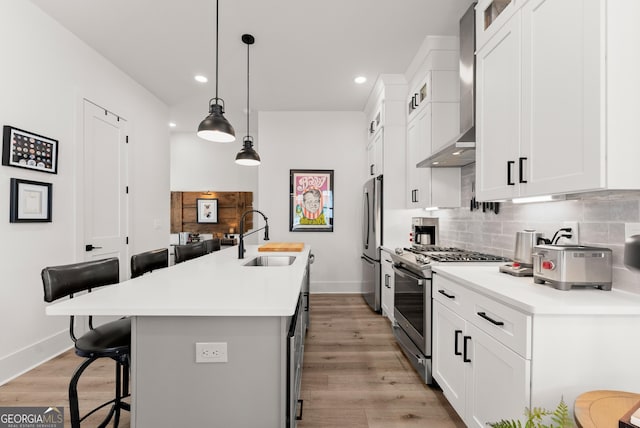 306 Clarendon Ct SE, Gainesville, GA 30501 - kitchen with stainless steel appliances, a kitchen bar, decorative backsplash, wall chimney range hood, and a center island with sink