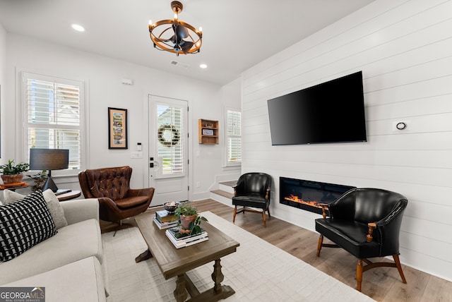 306 Clarendon Ct SE, Gainesville, GA 30501 - living area featuring wood finished floors, a chandelier, a glass covered fireplace, recessed lighting, and wood walls