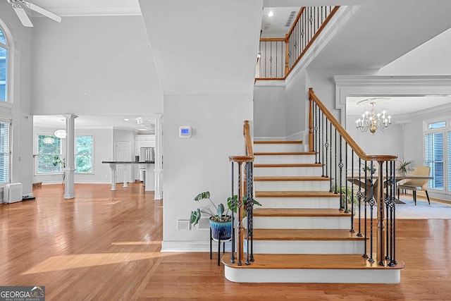 4030 Greatwood Path, Alpharetta, GA 30005 - staircase with a high ceiling, wood finished floors, plenty of natural light, crown molding, and a chandelier