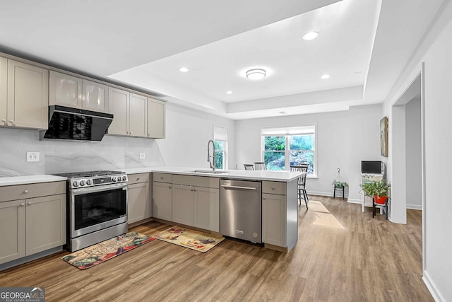 4030 Greatwood Path, Alpharetta, GA 30005 - kitchen featuring stainless steel appliances, gray cabinetry, a peninsula, light wood-type flooring, and a tray ceiling