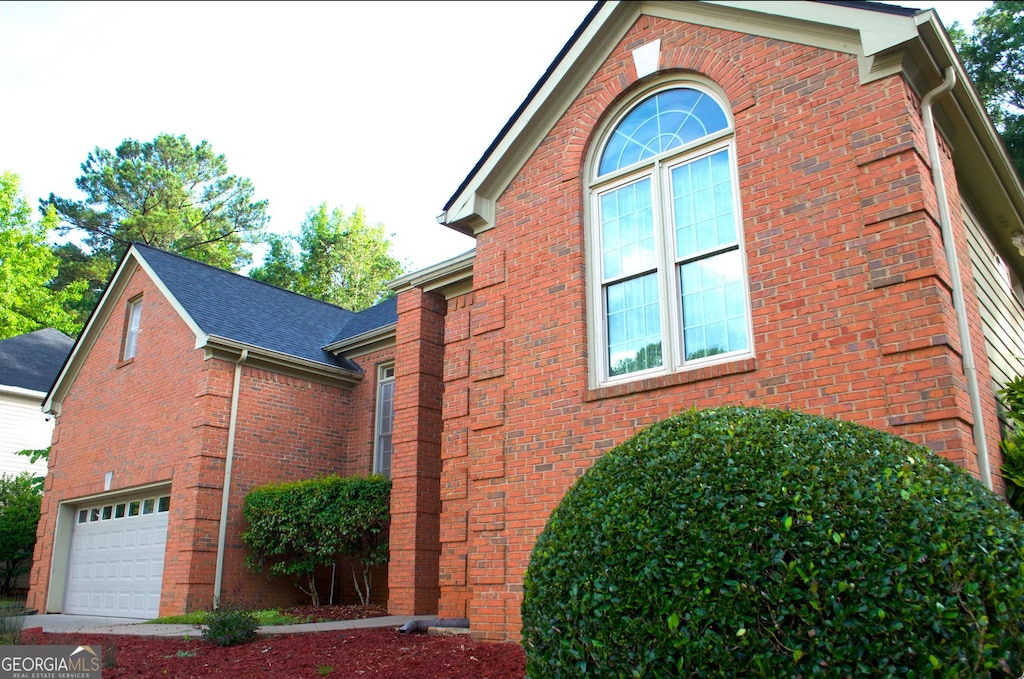 122 Carolinas Way, Fayetteville, GA 30215 - view of side of home with brick siding, an attached garage, and roof with shingles