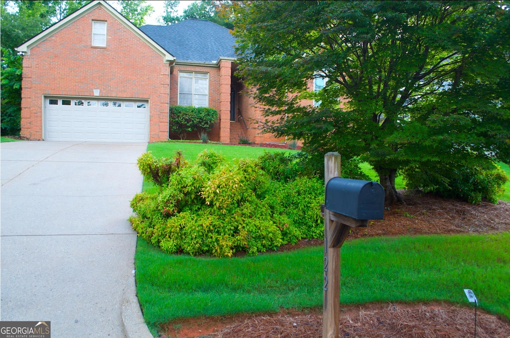 122 Carolinas Way, Fayetteville, GA 30215 - view of front facade with an attached garage, driveway, brick siding, and a front yard