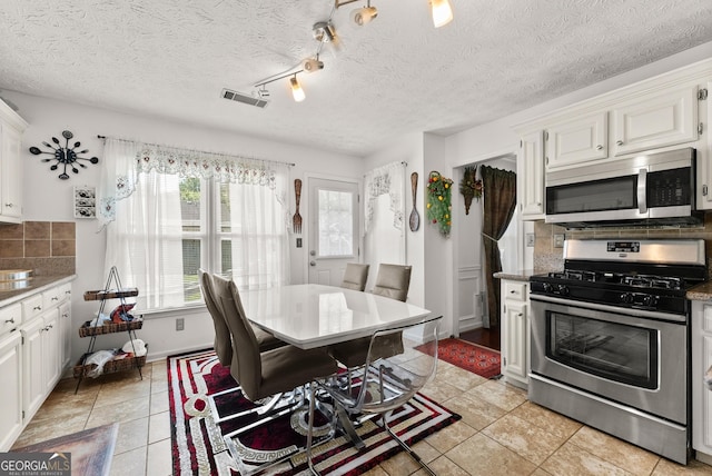 625 Hickory Nobb, Sugar Hill, GA 30518 - kitchen featuring stainless steel appliances, tasteful backsplash, white cabinets, light tile patterned floors, and a textured ceiling