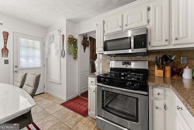 625 Hickory Nobb, Sugar Hill, GA 30518 - kitchen with stainless steel appliances, decorative backsplash, white cabinets, light tile patterned floors, and stone counters
