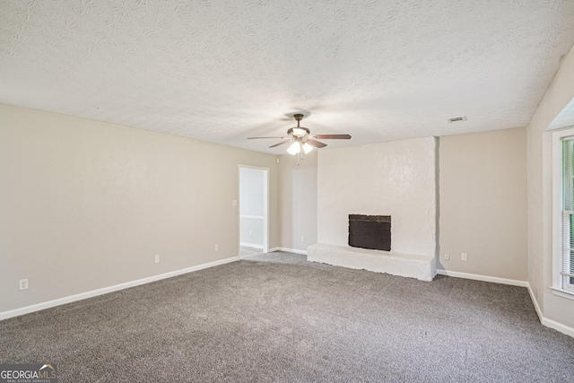 5618 Shadow Rock Dr, Lithonia, GA 30058 - unfurnished living room featuring a ceiling fan, carpet flooring, a fireplace with raised hearth, and a textured ceiling