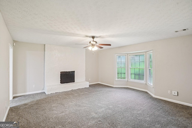 5618 Shadow Rock Dr, Lithonia, GA 30058 - unfurnished living room featuring ceiling fan, carpet flooring, a fireplace with raised hearth, and a textured ceiling