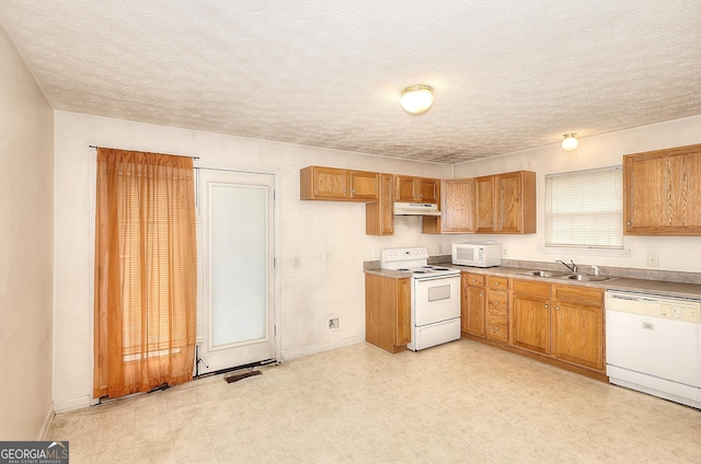 67 Cotton St, Commerce, GA 30529 - kitchen featuring white appliances, under cabinet range hood, brown cabinetry, light floors, and a textured ceiling
