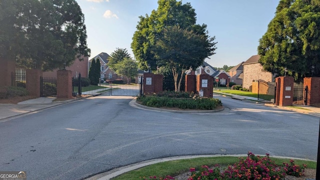 2435 Hickory Station Cir, Snellville, GA 30078 - view of asphalt road featuring a gate, sidewalks, curbs, a residential view, and a gated entry