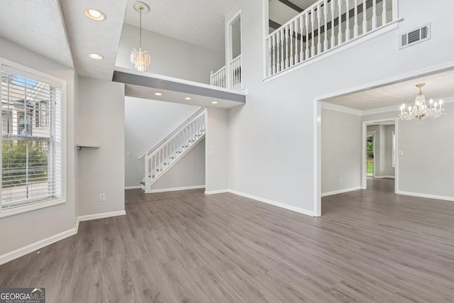 2379 Fallbrook Ct, Duluth, GA 30096 - unfurnished living room featuring a chandelier, stairs, wood finished floors, recessed lighting, and a towering ceiling