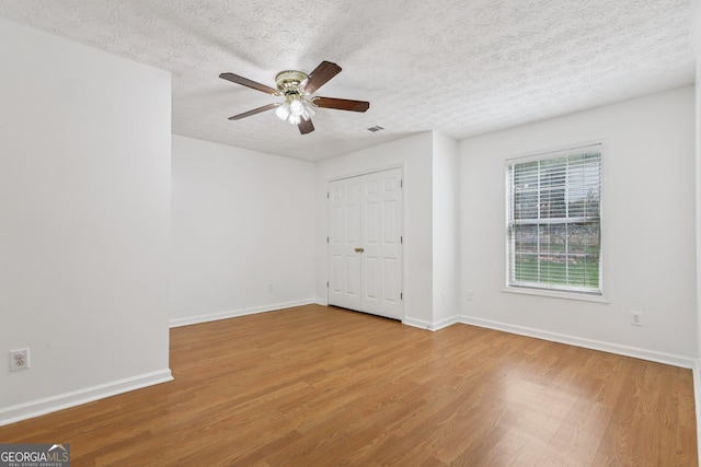 2379 Fallbrook Ct, Duluth, GA 30096 - empty room with wood finished floors, ceiling fan, and a textured ceiling