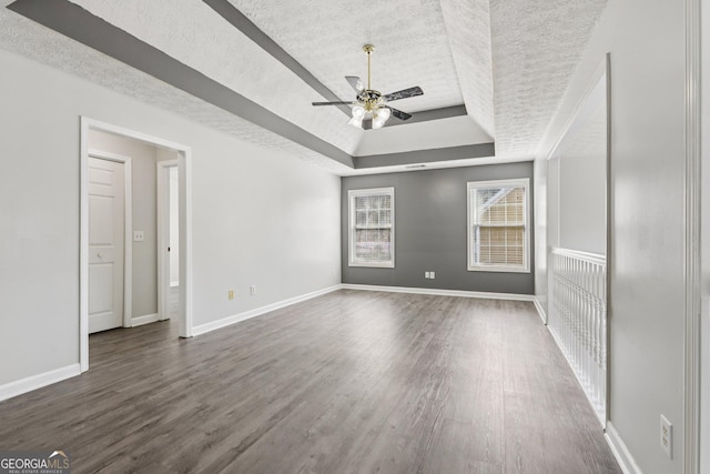 2379 Fallbrook Ct, Duluth, GA 30096 - unfurnished room featuring a textured ceiling, a raised ceiling, a ceiling fan, and dark wood-style floors