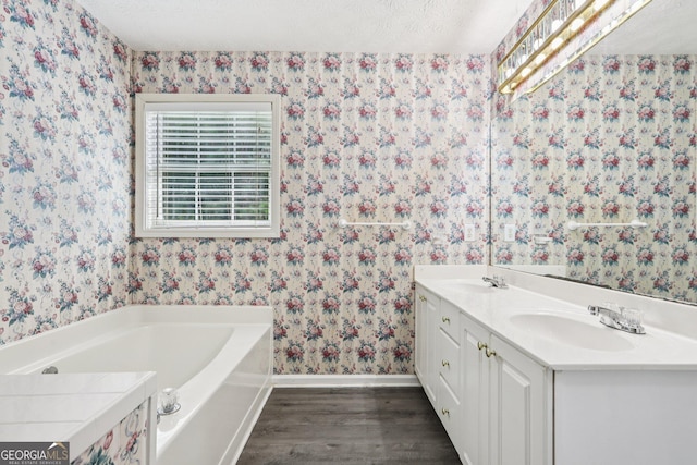 2379 Fallbrook Ct, Duluth, GA 30096 - full bath featuring wallpapered walls, wood finished floors, a bath, and double vanity
