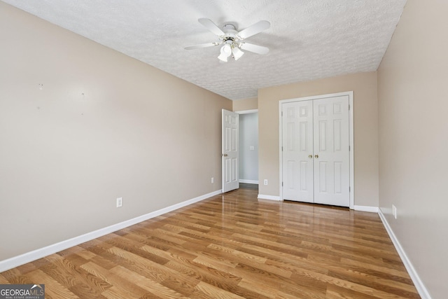2379 Fallbrook Ct, Duluth, GA 30096 - unfurnished bedroom with a textured ceiling, light wood-style floors, a closet, and a ceiling fan
