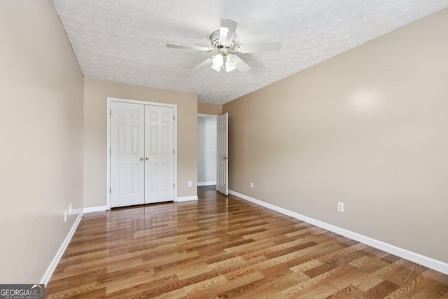 2379 Fallbrook Ct, Duluth, GA 30096 - unfurnished bedroom with a textured ceiling, wood finished floors, a closet, and ceiling fan