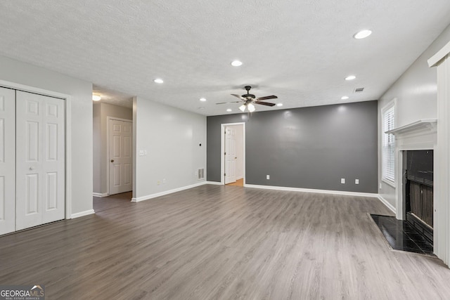 2379 Fallbrook Ct, Duluth, GA 30096 - unfurnished living room featuring a ceiling fan, a high end fireplace, recessed lighting, wood finished floors, and a textured ceiling
