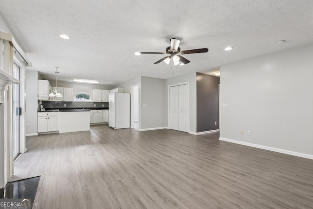 2379 Fallbrook Ct, Duluth, GA 30096 - unfurnished living room with a ceiling fan, wood finished floors, a textured ceiling, and recessed lighting