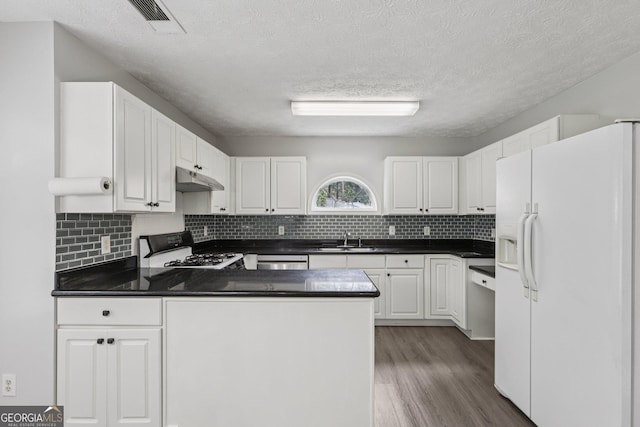 2379 Fallbrook Ct, Duluth, GA 30096 - kitchen featuring white refrigerator with ice dispenser, range with gas cooktop, under cabinet range hood, a peninsula, and dark countertops