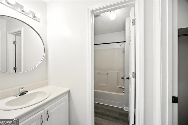 4801 Wilson Rd, Macon, GA 31206 - full bath featuring vanity, a textured ceiling, wood finished floors, and shower / tub combination