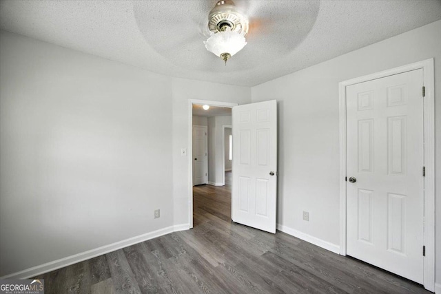 4801 Wilson Rd, Macon, GA 31206 - unfurnished bedroom with dark wood finished floors, a textured ceiling, and ceiling fan