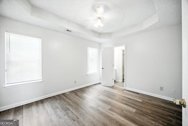 4801 Wilson Rd, Macon, GA 31206 - unfurnished bedroom featuring a raised ceiling, wood finished floors, and a textured ceiling
