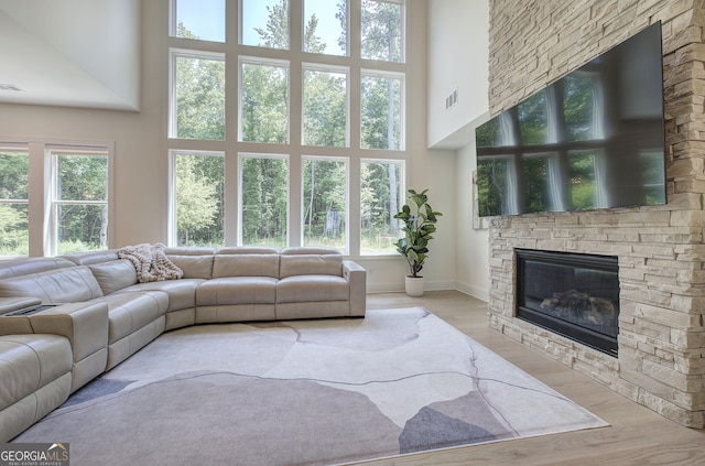 841 Keystone Dr, Woodstock, GA 30188 - living room featuring a stone fireplace, a high ceiling, plenty of natural light, and wood finished floors