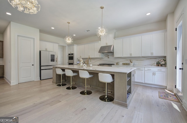 841 Keystone Dr, Woodstock, GA 30188 - kitchen with freestanding refrigerator, under cabinet range hood, decorative backsplash, white cabinets, and recessed lighting