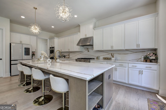 841 Keystone Dr, Woodstock, GA 30188 - kitchen with freestanding refrigerator, under cabinet range hood, a chandelier, white cabinets, and recessed lighting