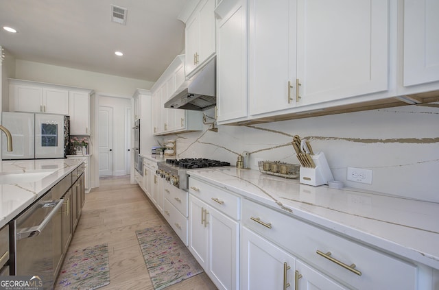 841 Keystone Dr, Woodstock, GA 30188 - kitchen with under cabinet range hood, appliances with stainless steel finishes, recessed lighting, white cabinets, and tasteful backsplash