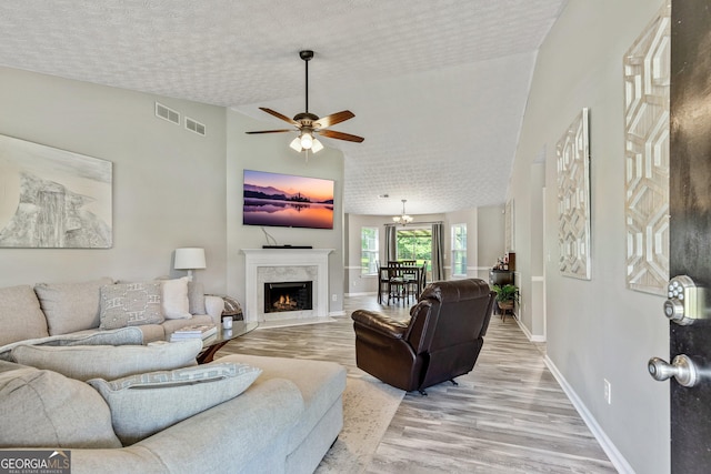 125 Meadow View Dr, Jackson, GA 30233 - living area with light wood finished floors, ceiling fan, a premium fireplace, and a textured ceiling