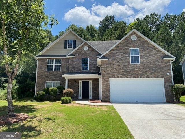 1472 Queenie Smith Rd NE, Conyers, GA 30012 - view of front of home featuring driveway, an attached garage, a front yard, and stone siding