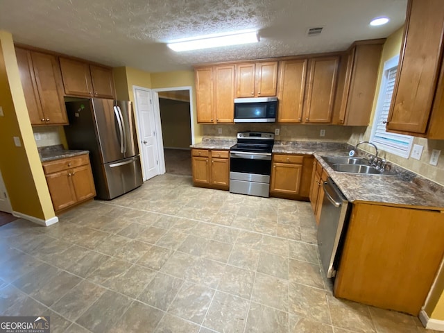 1472 Queenie Smith Rd NE, Conyers, GA 30012 - kitchen featuring appliances with stainless steel finishes, brown cabinetry, and a textured ceiling