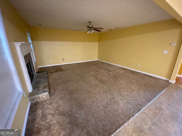 1472 Queenie Smith Rd NE, Conyers, GA 30012 - unfurnished living room with a ceiling fan, carpet flooring, and a fireplace with raised hearth