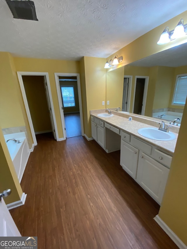 1472 Queenie Smith Rd NE, Conyers, GA 30012 - full bathroom with wood finished floors, a bath, double vanity, and a textured ceiling