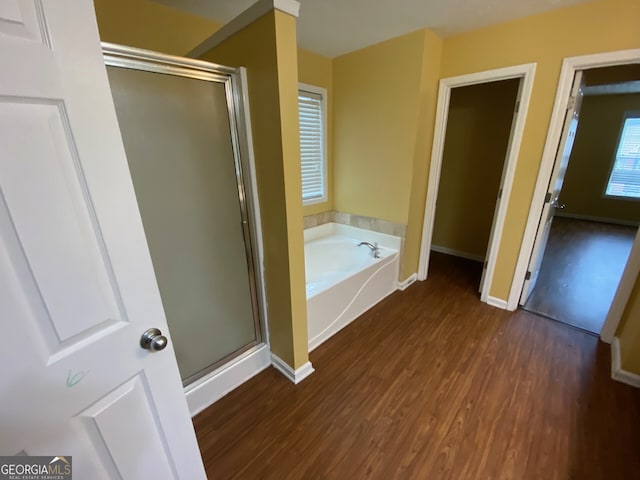 1472 Queenie Smith Rd NE, Conyers, GA 30012 - bathroom featuring wood finished floors, a stall shower, and a garden tub
