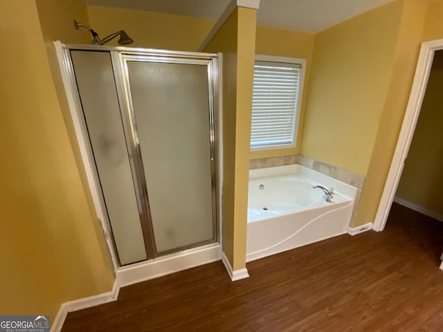 1472 Queenie Smith Rd NE, Conyers, GA 30012 - bathroom featuring a shower stall, a bath, and wood finished floors