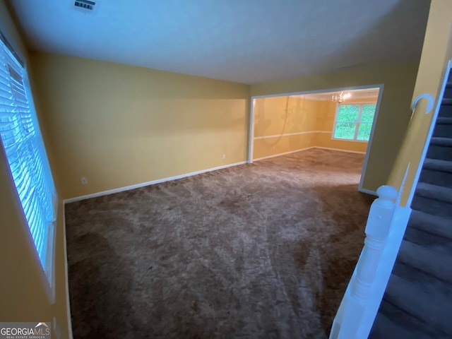 1472 Queenie Smith Rd NE, Conyers, GA 30012 - empty room with carpet floors, stairs, and a chandelier