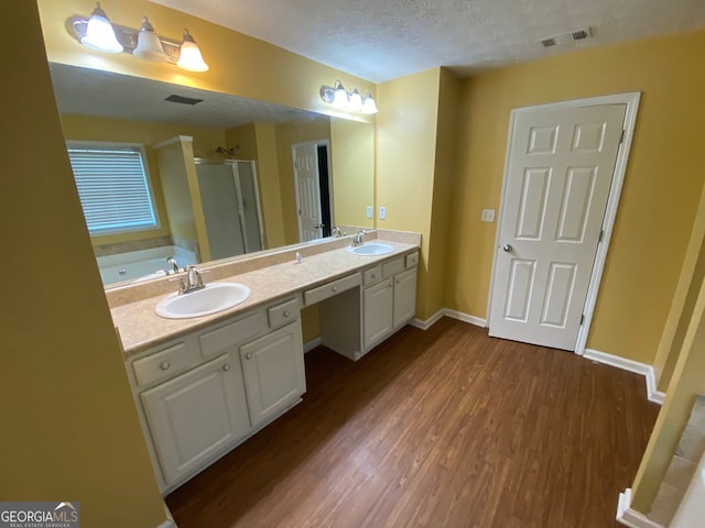 1472 Queenie Smith Rd NE, Conyers, GA 30012 - full bathroom featuring a shower stall, wood finished floors, double vanity, a bath, and a textured ceiling