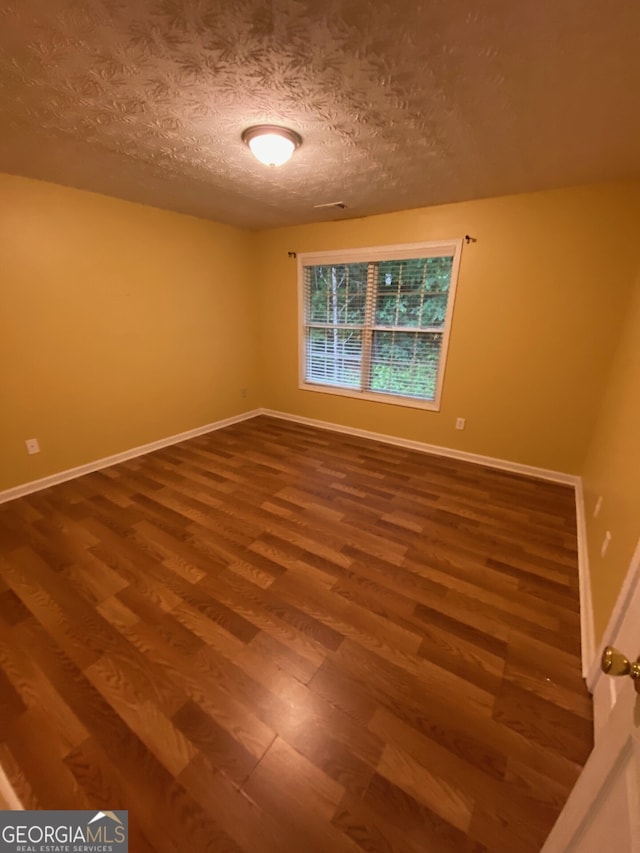 1472 Queenie Smith Rd NE, Conyers, GA 30012 - spare room featuring wood finished floors and a textured ceiling