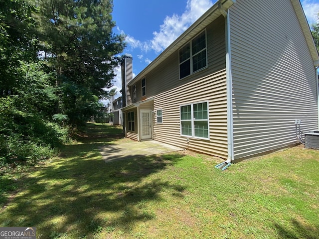 1472 Queenie Smith Rd NE, Conyers, GA 30012 - view of side of home featuring a lawn, a chimney, and a patio