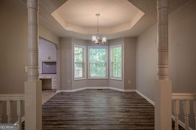 217 Bridgewater Trl, Canton, GA 30115 - unfurnished dining area with dark wood-type flooring, a textured ceiling, a tray ceiling, and a chandelier