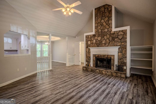 217 Bridgewater Trl, Canton, GA 30115 - unfurnished living room with wood finished floors, ceiling fan, a stone fireplace, high vaulted ceiling, and a chandelier