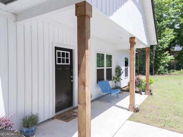 275 Bethlehem Church Rd, Carrollton, GA 30117 - view of exterior entry with board and batten siding, a yard, and a patio