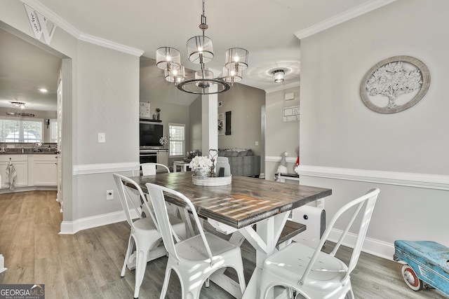 120 Mylee Cv, Barnesville, GA 30204 - dining space featuring light wood finished floors, a chandelier, and ornamental molding
