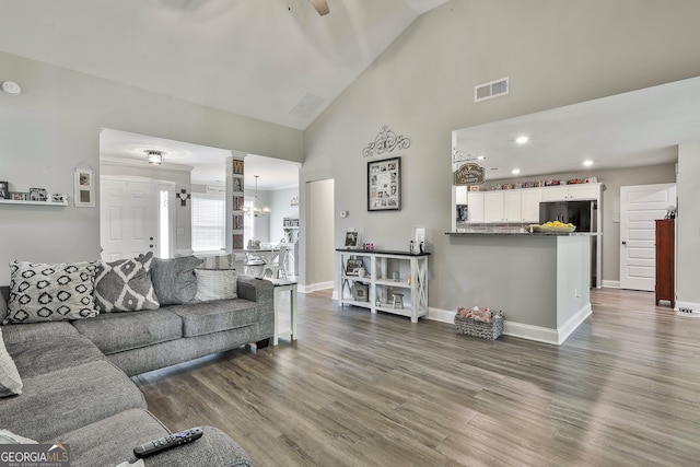 120 Mylee Cv, Barnesville, GA 30204 - living room featuring ceiling fan, dark wood-style floors, high vaulted ceiling, decorative columns, and a chandelier