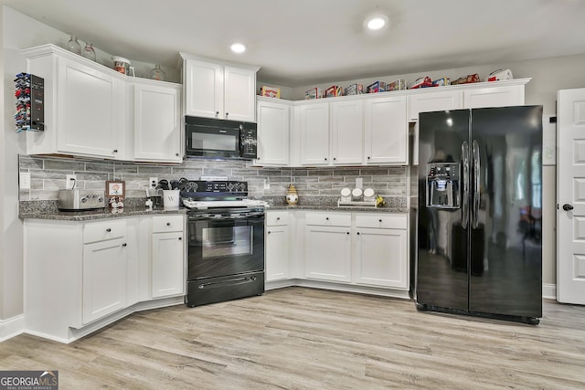 120 Mylee Cv, Barnesville, GA 30204 - kitchen with black appliances, white cabinetry, light wood finished floors, dark stone countertops, and backsplash