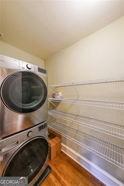 2 Collier Rd NW Unit 5, Atlanta, GA 30309 - laundry area featuring stacked washing machine and dryer and wood finished floors