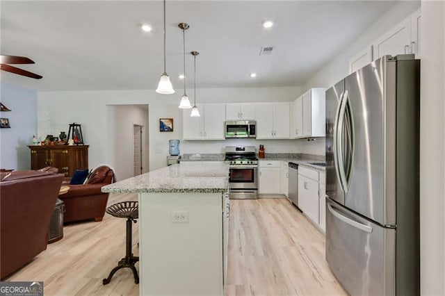 286 Kimberleys Xing, Jasper, GA 30143 - kitchen with appliances with stainless steel finishes, open floor plan, a ceiling fan, a kitchen bar, and a kitchen island